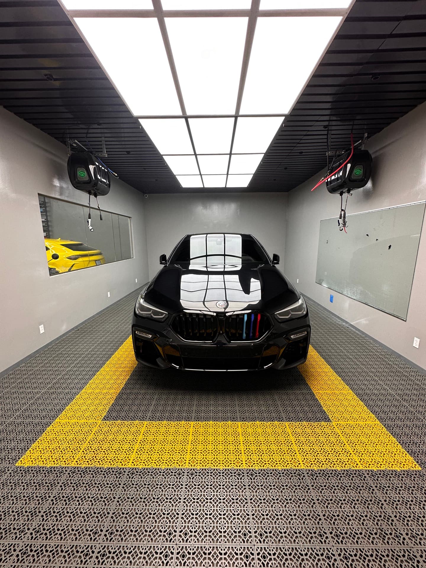 Black BMW X6 in detailing booth under studio lights