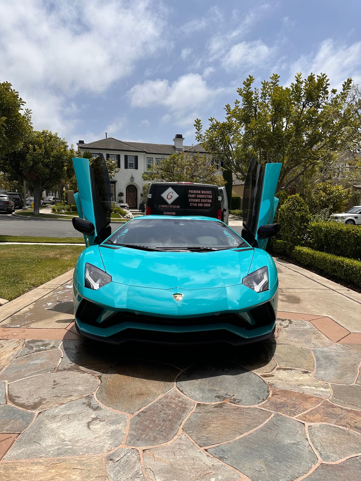 Baby blue Lamborghini Aventador front view with G Mobile van