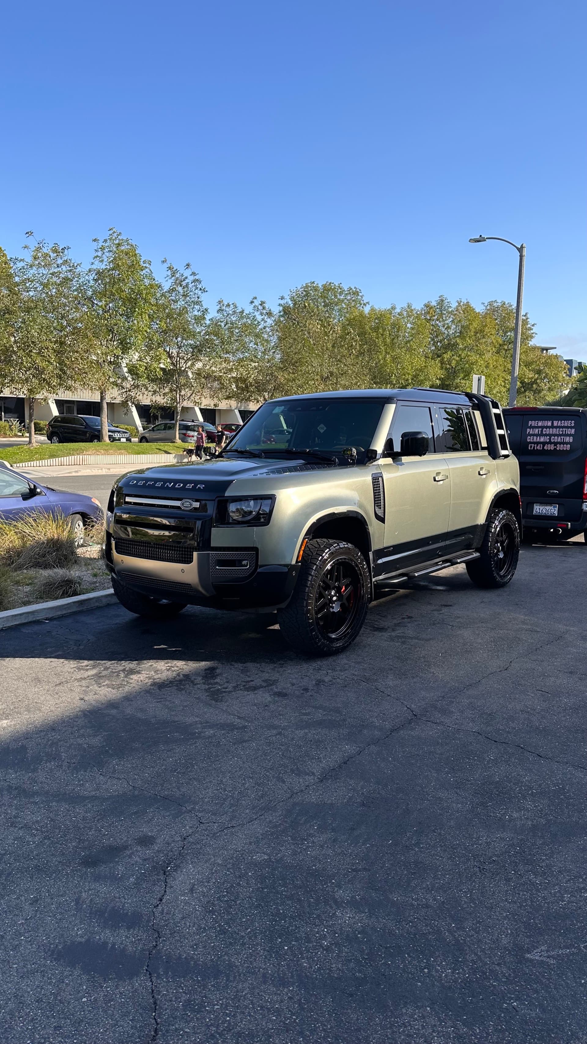 Green Land Rover Defender mobile detail with van in Orange County