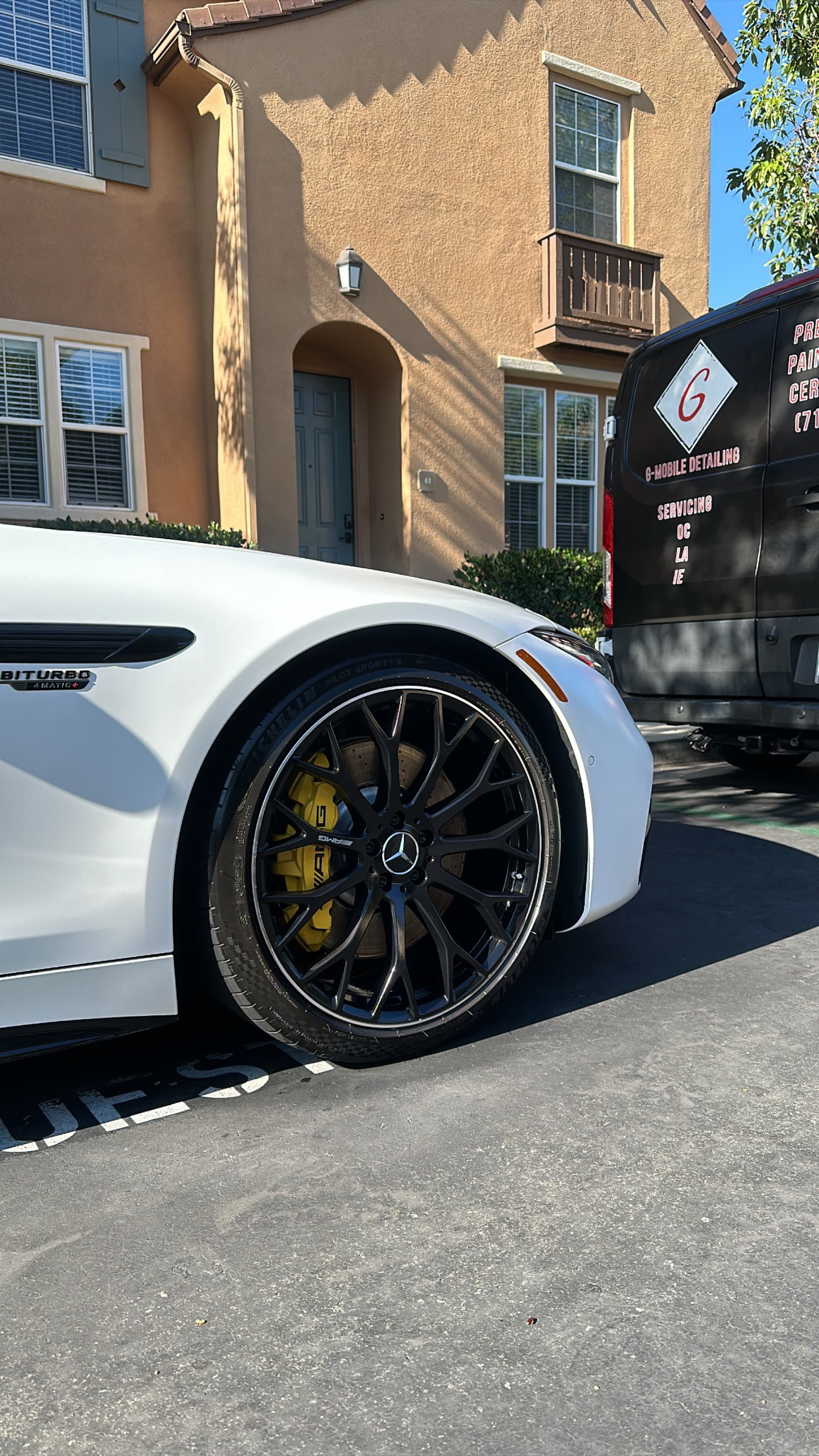 White Mercedes AMG GT wheel detail with G Mobile van