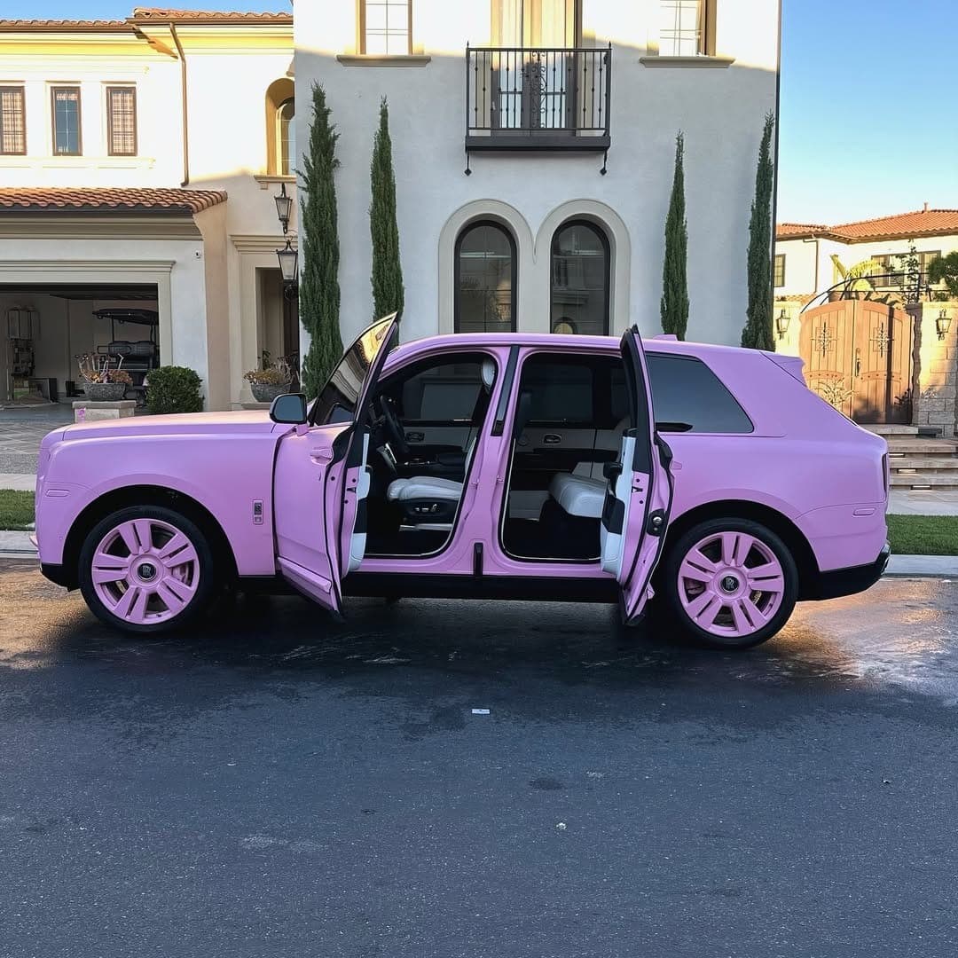 Pink Rolls-Royce Cullinan with doors open in the driveway, detailed by G Mobile Detailing in Orange County