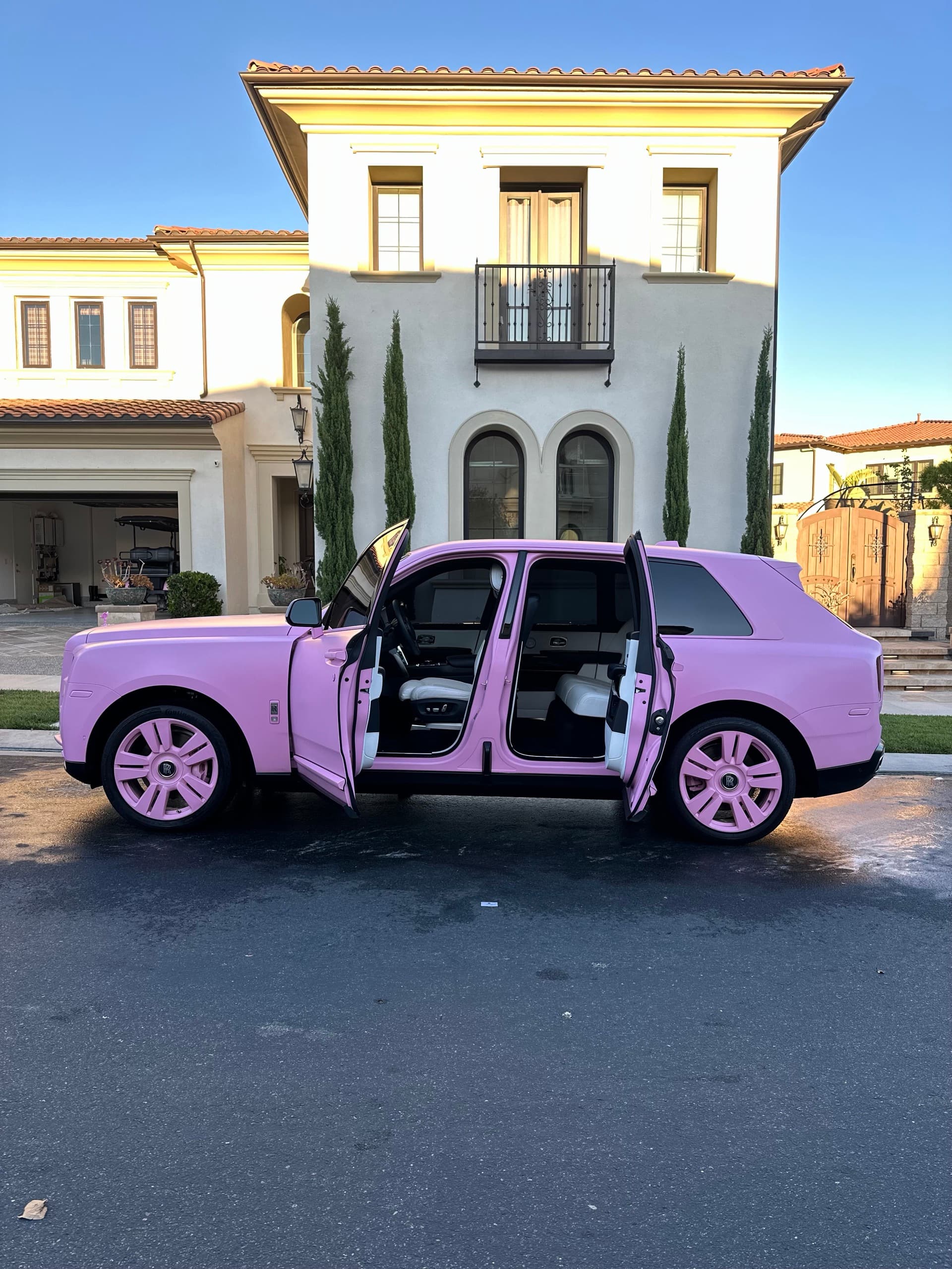 Pink Rolls Royce Cullinan doors open at mansion in Orange County