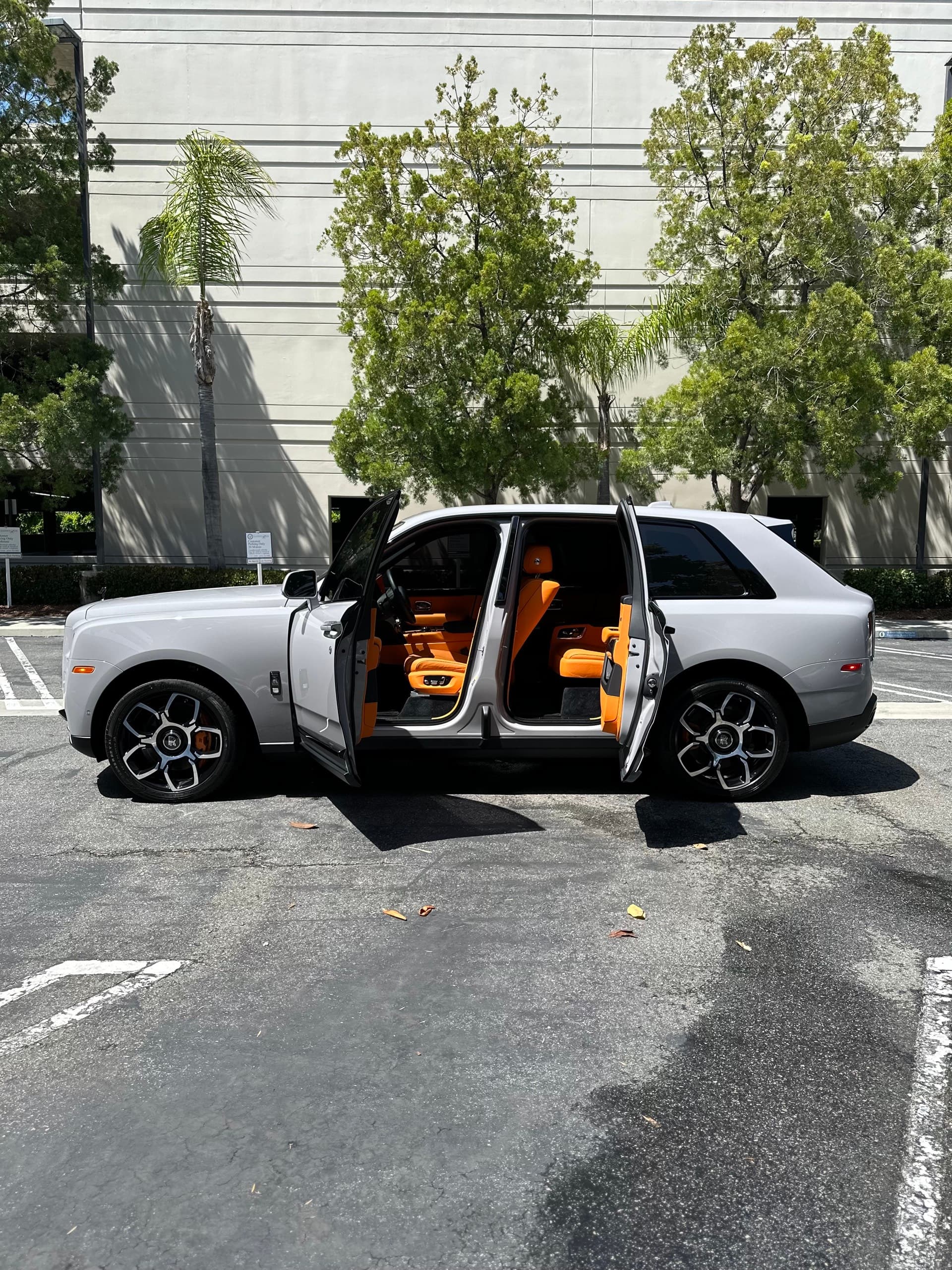 White Rolls Royce Cullinan with doors open showing tan interior after full detail