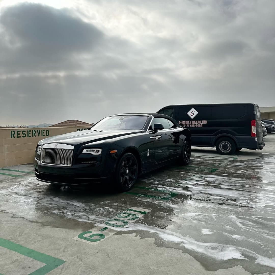 The same Rolls-Royce Dawn finished — deep black gloss in the same rooftop spot